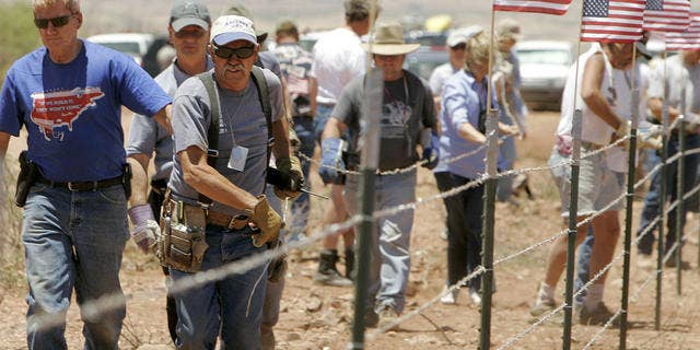In this 2006 photo, Minuteman volunteers build a fence along the U.S./Mexican border near Palominas, Ariz., in the hope of reducing illegal immigration. Now, border militias in the state are gaining support after a bill that would have created a civilian border group failed in the state Legislature.