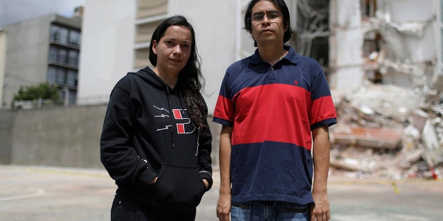 Miriam Anahí Abadia and her husband Led Esau Ramírez pose for a photo on September 24, 2017 in front of the building where they lived in Mexico City, which collapsed during the earthquake on September 19.