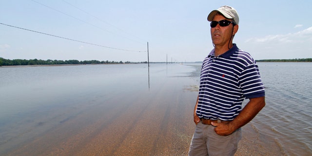 June 1: Farmer Brett Robinson stands on the road between his flooded farm fields near his house outside of Yazoo City, Miss.