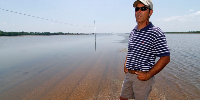 June 1: Farmer Brett Robinson stands on the road between his flooded farm fields near his house outside of Yazoo City, Miss.