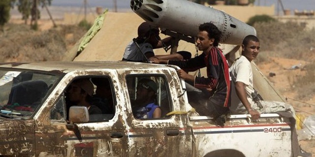 Sept. 14: Anti-Qaddafi fighters drive with a converted missile launcher from an aircraft near a check point.