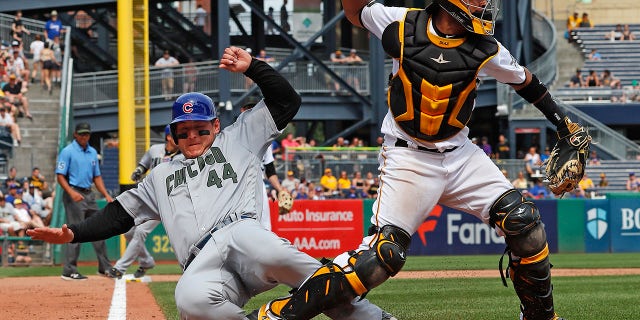 Pittsburgh Pirates catcher Elias Diaz, right, throws to first after getting the force-out at home plate on Chicago Cubs' Anthony Rizzo (44) on a fielder's choice to shortstop by Cub's Chris Gimenez in the eighth inning of a baseball game in Pittsburgh.