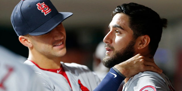 St. Louis Cardinals starting pitcher Daniel Poncedeleon, right, gets a hug in the dugout by Jack Flaherty, left, following seven no-hit innings against the Cincinnati Reds in a baseball game.
