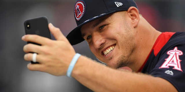 Los Angeles Angels outfielder Mike Trout takes a photo on the field ahead of the Home Run derby during the All-Star Game festivities.