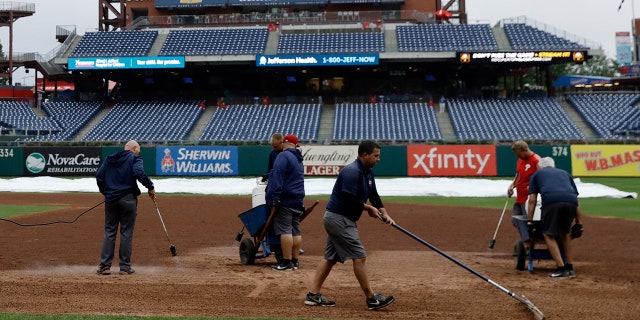Grounds crew members attempted to dry the Phillies' infield with blow torches.