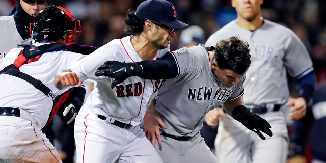 New York Yankees' Tyler Austin, right, scuffles with Boston Red Sox relief pitcher Joe Kelly, after being hit by a pitch during the seventh inning of a baseball game at Fenway Park in Boston.