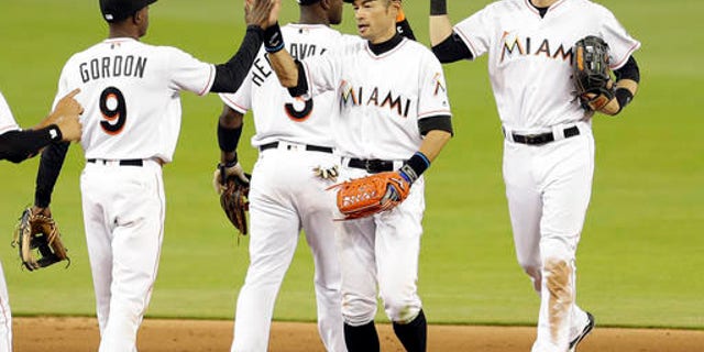 Miami Marlins right fielder Ichiro Suzuki, right foreground, gives a high-five to teammate Dee Gordon (9) after a baseball game against the Washington Nationals, Thursday, April 21, 2016, in Miami. The Marlins won 5-1. (AP Photo/Alan Diaz)