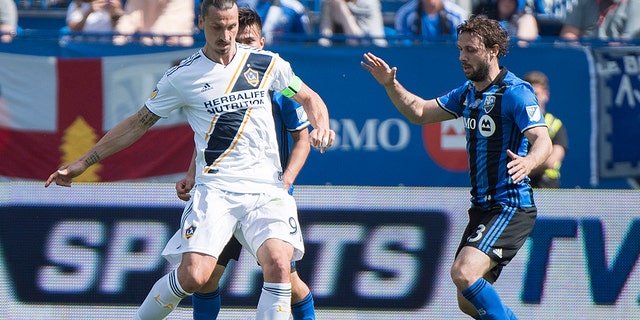 Montreal Impact's Marco Donadel moves in on Los Angeles Galaxy's Zlatan Ibrahimovic, left, during the first half an MLS soccer match in Montreal.