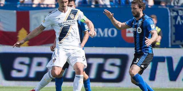 Montreal Impact's Marco Donadel moves in on Los Angeles Galaxy's Zlatan Ibrahimovic, left, during the first half an MLS soccer match in Montreal.