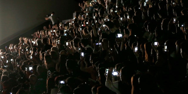 Guests and journalists take picture with their mobile phones during Japanese designer Yoshiyuki Miyamae Spring/Summer 2015 women's ready-to-wear collection show for fashion house Issey Miyake during Paris Fashion Week September 26, 2014. REUTERS/Charles Platiau (FRANCE - Tags: FASHION) - RTR47T3X