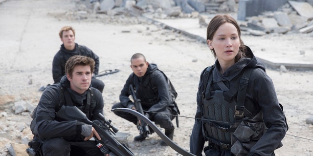 Liam Hemsworth, left, as Gale Hawthorne, Sam Clafin, back left, as Finnick Odair, Evan Ross, back right, as Messalia, and Jennifer Lawrence, right, as Katniss Everdeen, in the film, "The Hunger Games: Mockingjay - Part 2."
