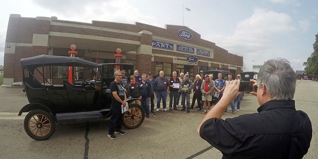 In this Aug. 31, 2017 photo, Gilmore Car Museum official Jay Follis takes a photo of students who completed the museum's Model T driving class in Hickory Corners, Mich. More than 500 people this year took the one-day, four-hour course offered by the museum near Kalamazoo. (AP Photo/Mike Householder)