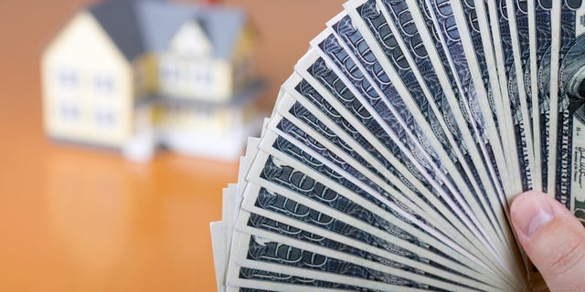 money-fanned-in-front-of-house