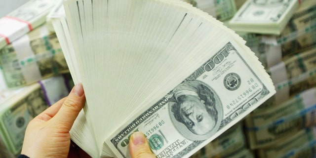 SEOUL, SOUTH KOREA - FEBRUARY 22: A South Korean banker carries US dollar bank notes at the Korea Exchange bank on February 22, 2005 in Seoul, South Korea. The South Korean won jumped to its highest intraday level in more than seven years in domestic trade on Tuesday, boosted by strong foreign equity buying and exporter deals. (Photo by Chung Sung-Jun/Getty Images)