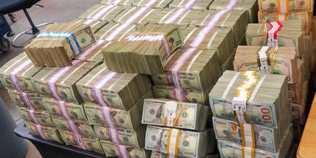 This Aug. 26, 2016 photo provided by the U.S. Border Patrol shows some of more than $3 million in cash that two men were trying to smuggle into Mexico from California. The agency says its agents tracked and stopped a Kia Forte in Escondido, Calif., on Tuesday, Aug. 23, and found nearly $34,000 stashed in the car's center console. Another car, a Volkswagen Passat, sped away, and when found a short time later had more than $3 million, shown here, packed in boxes in the trunk. (U.S. Border Patrol via AP)