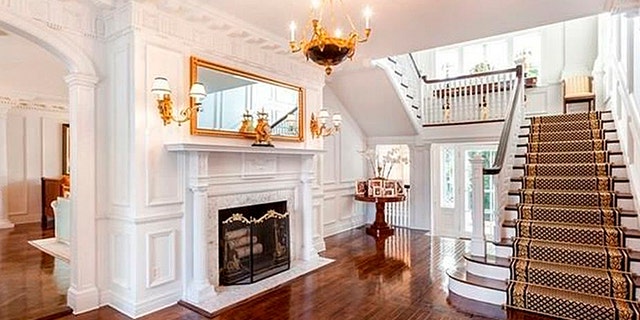 A golden chandelier and grand staircase welcome guests into the home.