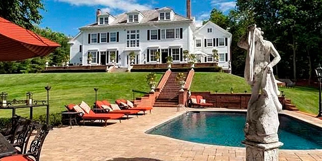 A shot from the backyard of the pool and patio area.
