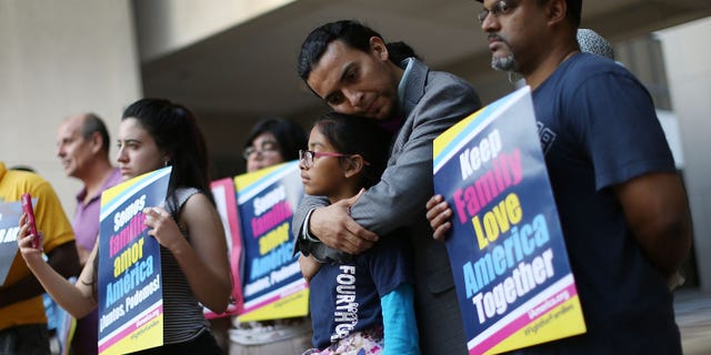 MIAMI, FL - APRIL 18: Danilo Balladares holds onto Dely Balladares as they join others during a vigil to support President Barack Obama's immigration executive action on April 18, 2016 in Miami, Florida. The U.S. Supreme Court started to hear oral argument on President Obama's deferred action initiatives, DAPA and expanded DACA. (Photo by Joe Raedle/Getty Images)