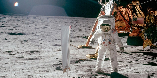 Buzz Aldrin stands on lunar surface in front Lunar Landing Module during Apollo 11's lunar mission.