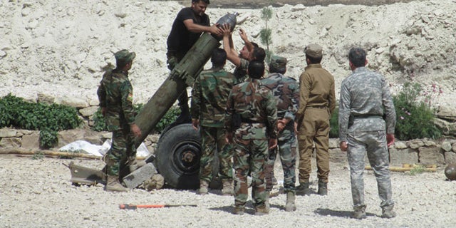 When it was ready to fire, the Peshmerga fighters crouched behind sandbags in case the mortar blew up.
