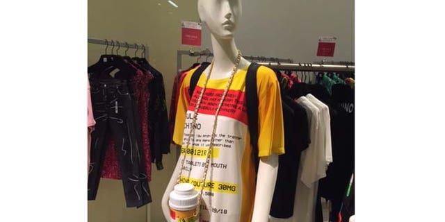 The $995 Moschino Capsule minidress and $950 pill bottle shoulder bag on display at Saks Fifth Avenue in Manhattan.