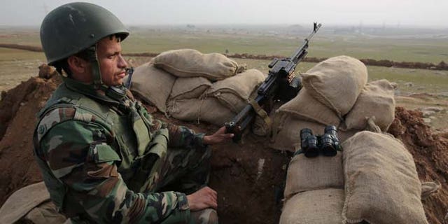 Jan. 27, 2015: A Kurdish Peshmerga soldier stands guard, overlooking the road between Mosul and Tal afar at the frontline of Eski Mosul. (AP)