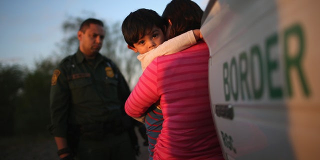 RIO GRANDE CITY, TX - DECEMBER 07: A one-year-old from El Salvador clings to his mother after she turned themselves in to Border Patrol agents on December 7, 2015 near Rio Grande City, Texas. They had just illegally crossed the U.S.-Mexico border into Texas. The mother said she brought her son on the 24-day journey from El Salvador to escape violence in the Central American country. The number of migrant families and unaccompanied minors has again surged in recent months, even as the total number of illegal crossings nationwide has gone down over the previous year. (Photo by John Moore/Getty Images)