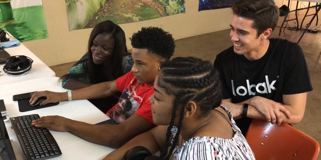 Michael Bezzina (rear) helps VR curators (left to right) Shalin Jewett, Deuntay Williams and Mya Calhoun edit at a workstation at Lobaki Inc. in Clarksdale, Miss.