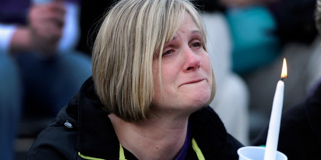 A woman cries during a vigil for Maren Sanchez at Jonathan Law High School, Monday, April 28, 2014, in Milford, Conn. Sanchez was fatally stabbed inside the school on Friday hours before her junior prom. (AP Photo/Jessica Hill)
