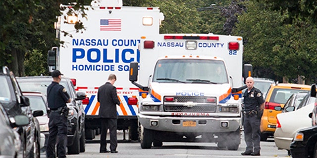 Nassau and Hempstead police investigate the scene of a triple homicide in Hempstead, N.Y., Saturday.