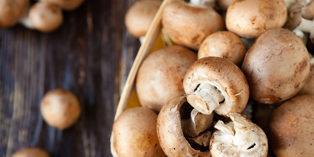 champignons in a basket on dark boards, food