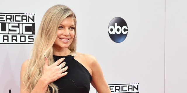 FILE - In this Nov. 23, 2014, file photo, Fergie arrives at the 42nd annual American Music Awards at Nokia Theatre L.A. Live in Los Angeles. Fergie said the concept for her latest hit âM.I.L.F. $â was in the works for several years, and sheâs hoping to inspire and empower mothers to find a balance between motherhood, career life and âme time.â The song and white-hot video, co-starring Kim Kardashian, Chrissy Teigen, Ciara and others, debuted Friday, July 1, 2016, and quickly became a trending topic on social media. (Photo by John Shearer/Invision/AP, File)