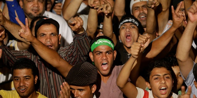 July 10, 2013: Supporters of ousted Egypt's President Mohammed Morsi shout slogans during a demonstration after the Iftar prayer, evening meal when Muslims break their fast during the Islamic month of Ramadan, in Nasr City, Cairo, Egypt.