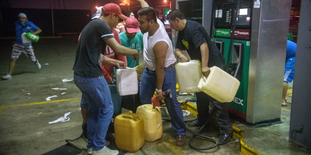 Residents pilfer gasoline and diesel from a gas station in Allende, Mexico, Jan. 3, 2017.