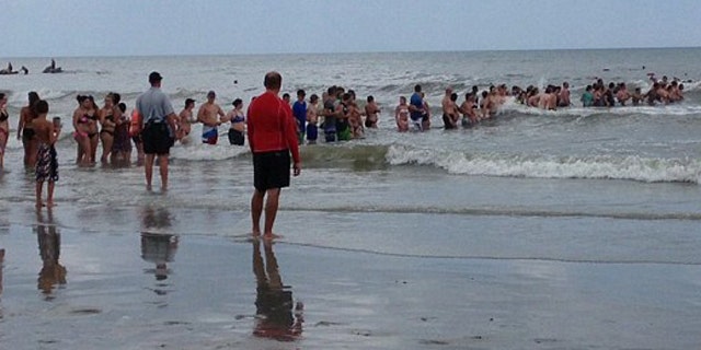 June 16, 2016: Beachgoers form a human chain to aid the search for a 14-year-old boy who vanished while swimming in Myrtle Beach, S.C.