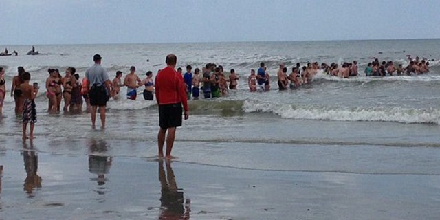 June 16, 2016: Beachgoers form a human chain to aid the search for a 14-year-old boy who vanished while swimming in Myrtle Beach, S.C.