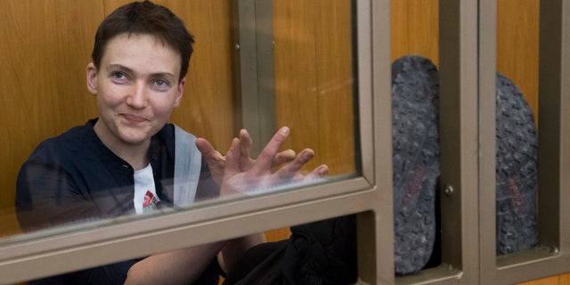 March 22, 2016: Ukrainian pilot Nadezhda Savchenko waves to journalists from a glass cage inside court, in the town of Donetsk, Rostov-on-Don region, Russia.