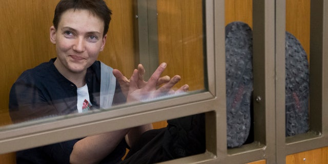 March 22, 2016: Ukrainian pilot Nadezhda Savchenko waves to journalists from a glass cage inside court, in the town of Donetsk, Rostov-on-Don region, Russia.