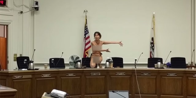 Activist Gypsy Taub climbs onto the dais after the Berkeley, Calif. City Council tabled a proposed ordinance that would allow women to go topless in public.