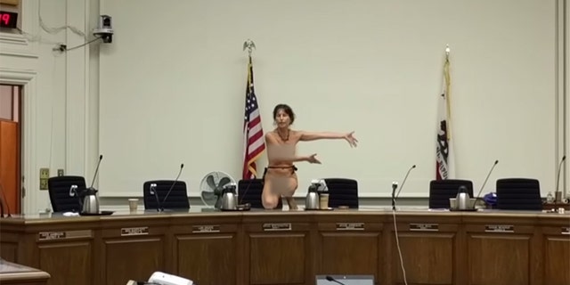 Activist Gypsy Taub climbs onto the dais after the Berkeley, Calif. City Council tabled a proposed ordinance that would allow women to go topless in public.