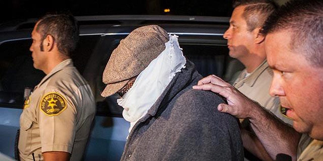 Nakoula, seen here in 2013 being escorted out of his home in Cerritos, Calif., lives under constant threat.