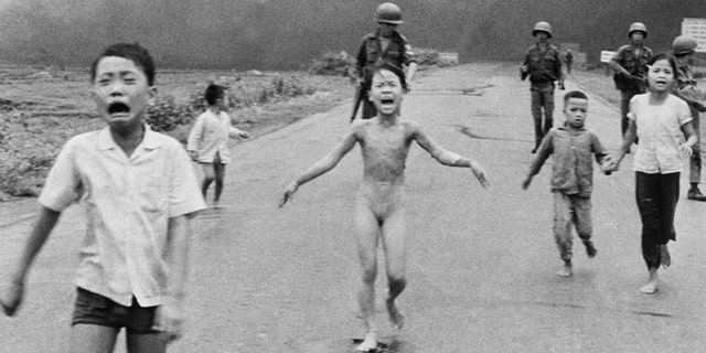 In this June 8, 1972, file photo, 9-year-old Kim Phuc, center, runs with her brothers and cousins, followed by South Vietnamese forces, down Route 1 near Trang Bang after a South Vietnamese plane accidentally dropped its flaming napalm on its own troops and civilians. The terrified girl had ripped off her burning clothes while fleeing.