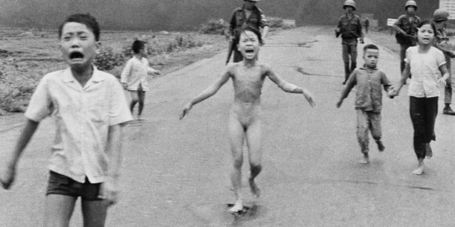 In this June 8, 1972, file photo, 9-year-old Kim Phuc, center, runs with her brothers and cousins, followed by South Vietnamese forces, down Route 1 near Trang Bang after a South Vietnamese plane accidentally dropped its flaming napalm on its own troops and civilians. The terrified girl had ripped off her burning clothes while fleeing.