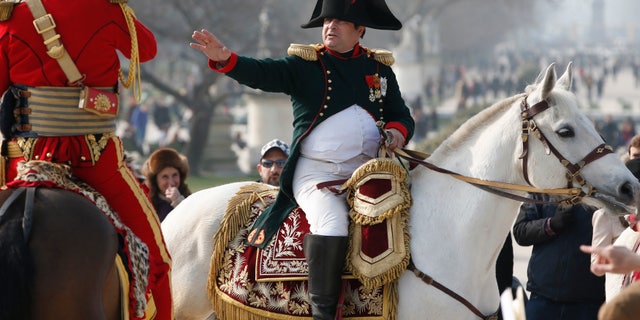 Frenchman Frank Samson takes part in an re-enactment as French Emperor Napoleon who rides on horseback in the Tuileries Gardens upon his return to Paris, as part of the Bicentennial, in Paris March 20, 2015. This year marks the bicentennial of the return of Napoleon Bonaparte to France after nine months of exile on the Island of Elba. REUTERS/Charles Platiau - RTR4U7KG