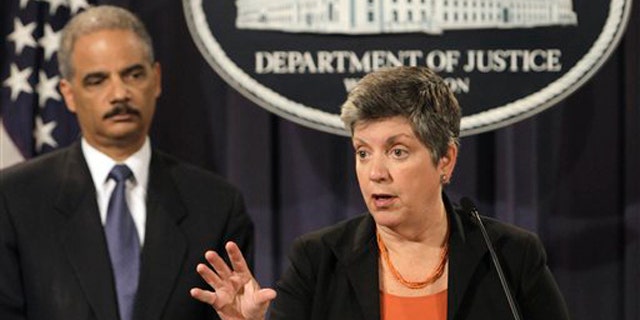 Attorney General Eric Holder, left, listens as Homeland Security Secretary Janet Napolitano speaks at the Justice Department in Washington Aug. 3.