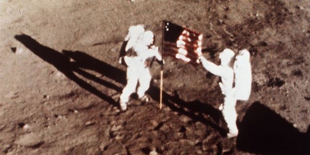 Apollo 11 astronauts Neil Armstrong and Buzz Aldrin plant an American flag on the surface of the moon in July 1969.