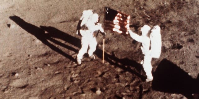 Apollo 11 astronauts Neil Armstrong and Buzz Aldrin plant an American flag on the surface of the moon in July 1969.