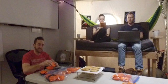 In this 2017 photo released by the University of Hawaii crew members of Mission V, from left, Joshua Ehrlich, Ansley Barnard and James Bevington work inside the university’s facility Hawaii Space Exploration Analog and Simulation (HI-SEAS) at the Mauna Loa volcano, Big Island, Hawaii. (University of Hawaii via AP)