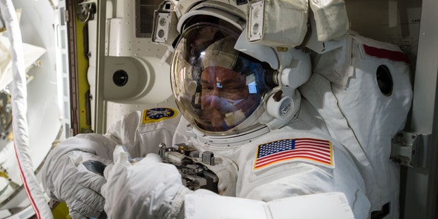 In this photo provided by NASA and posted on Twitter on Oct. 26, 2015, astronaut Scott Kelly tries on his spacesuit inside the U.S. Quest airlock of the International Space Station. NASA opened its astronaut-application website Monday, Dec. 14, 2015. It's accepting applications through Feb. 18, 2016. (NASA via AP)