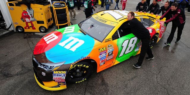 KANSAS CITY, KS - OCTOBER 14: Crew members push the #18 M&M's Toyota, driven by Kyle Busch, in the garage area prior to practice for the NASCAR Sprint Cup Series Hollywood Casino 400 at Kansas Speedway on October 14, 2016 in Kansas City, Kansas. (Photo by Jeff Curry/Getty Images)